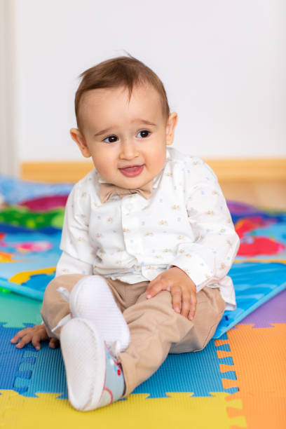 istock Cute elegant baby boy sitting on floor 1192644185