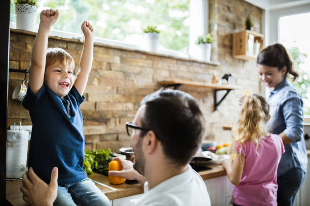 istock Happy boy celebrating while being with his family in the kitchen. 1192644374