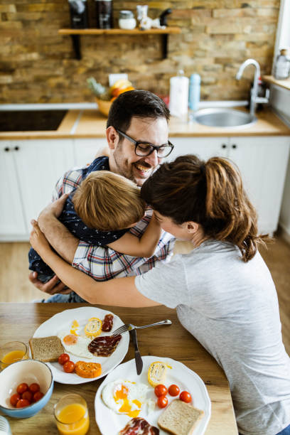istock Young happy family embracing during breakfast at dining table. 1192644628