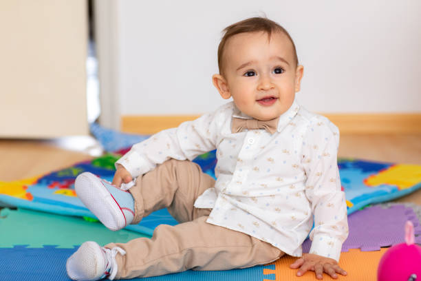 istock Cute elegant baby boy sitting on floor 1192645559