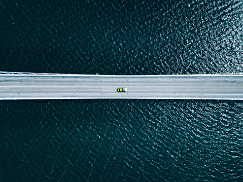 Aerial view of bridge road with cars over lake or sea in Finland