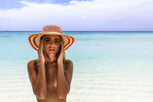 istock Young beautiful woman with sun hat on the beach. 1192647867