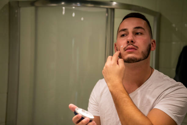 istock A Handsome Young man is Putting an After-Shave Cream 1192651101