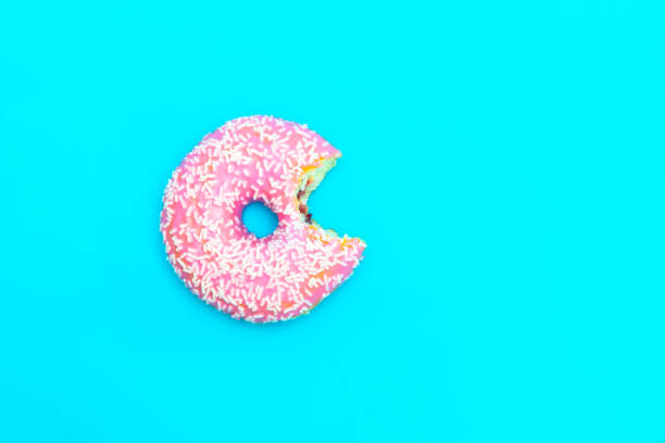 istock Top view of bitten glazed donut on blue background with copy space 1192651452