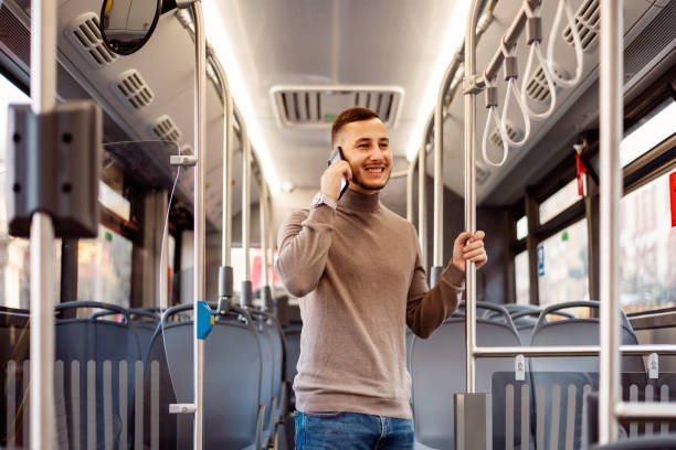 istock Attractive Young Man is Speaking over his Smart Phone in the Bus 1192653731