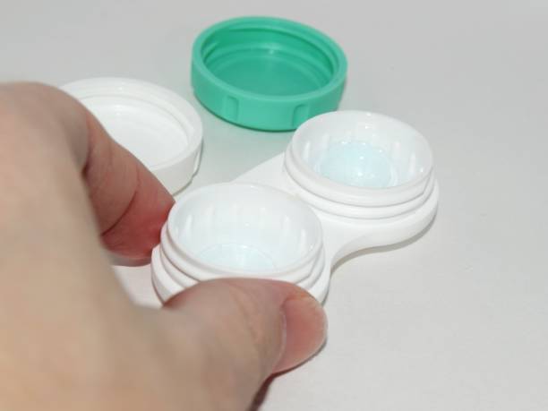 istock container with contact lenses for vision correction with a hand in a close-up frame on a gray background. 1192653848