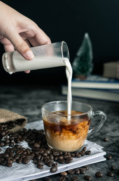 barista che fa latte. versando a mano il latte in una tazza di caffè espresso, preparando la bevanda al caffè. immagine verticale, ripresa ritagliata - thai cuisine asian cuisine vertical close up foto e immagini stock