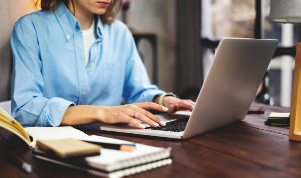 istock Young woman working with a laptop. Female freelancer connecting to internet via computer. Blogger or journalist writing new article. 1192656342