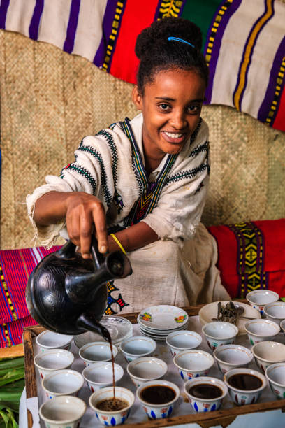 молодая африканская девушка готовит кофе, эфиопия. восточная африка - ethiopian coffee стоковые фото и изображения