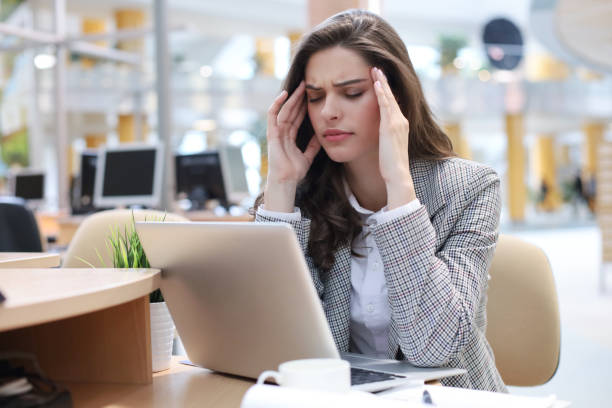 istock Frustrated business woman looking exhausted while sitting at her working place 1192660119