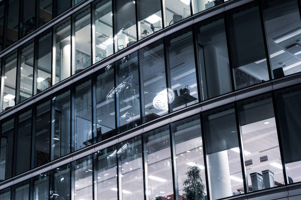 istock Modern offices in a large glass fronted building at night 1192660235
