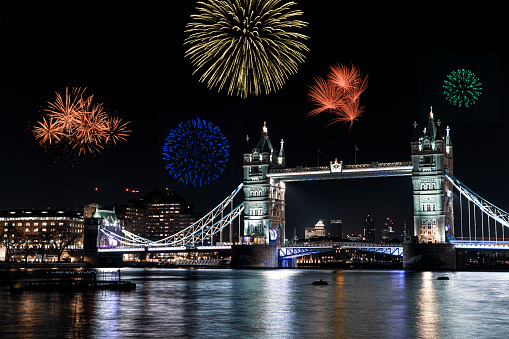 Londons Tower Bridge on the river Thames at night with fireworks being launched in celebration of New Year’s eve