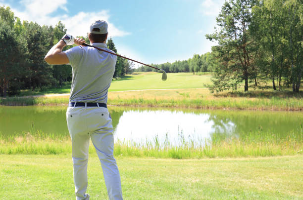 istock Athletic young man playing golf in golf club. 1192661084