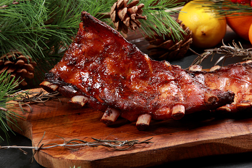 Grilled Baby Back Ribs with Lemon Zest and Christmas Decoration Background