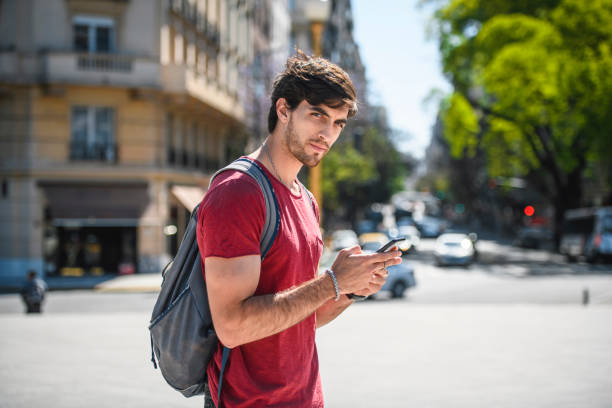 istock Serious Male Backpacker in Mid 20s Checking Smart Phone 1192666365