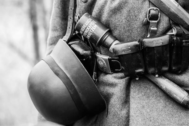 Part of the uniform of a German soldier Wehrmacht German soldier Wehrmacht uniform. Helmet, hand grenade and belt pouch for cartridges. Black and white shot battle reenactment stock pictures, royalty-free photos & images