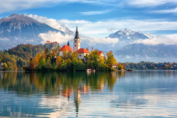 Famous alpine Bled lake (Blejsko jezero) in Slovenia, amazing autumn landscape. Scenic view of the lake, island with church, Bled castle, mountains and blue sky Famous alpine Bled lake (Blejsko jezero) in Slovenia, amazing autumn landscape. Scenic view of the lake, island with church, Bled castle, mountains and blue sky with clouds, outdoor travel background gorenjska stock pictures, royalty-free photos & images