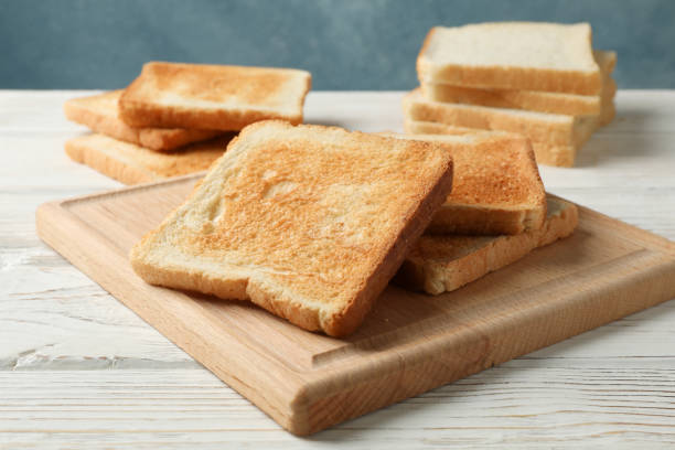 istock Board with toasts on white wooden background, close up 1192668087