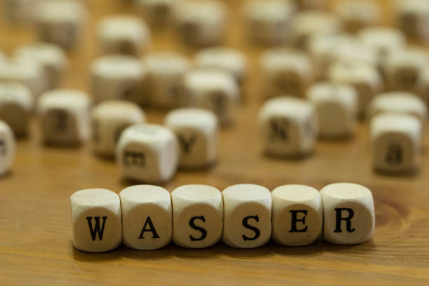 Water written in German with wooden cube