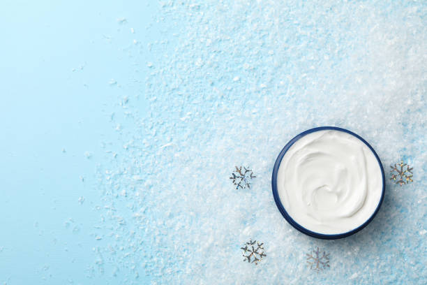 istock Winter cream for skin on snowy blue background, space for text. Top view 1192670357