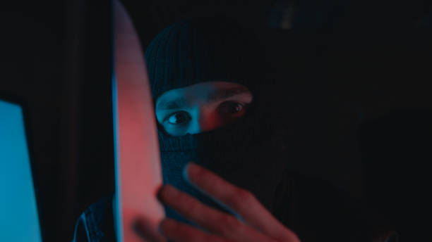 istock A thief with mask holding a knife threaten someone. Thief concept 1192671455