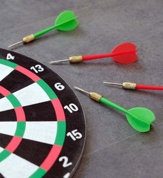 istock dartboard and dart arrows standing on white ground, 1192672389