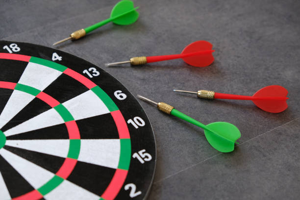 istock dartboard and dart arrows standing on white ground, 1192672409