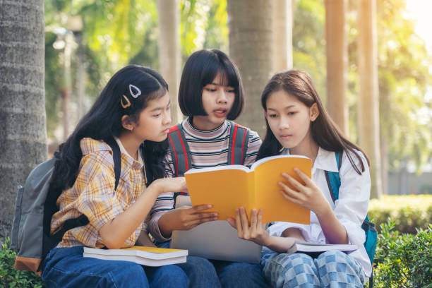 istock Group student young people and education reading book in city park 1192674004
