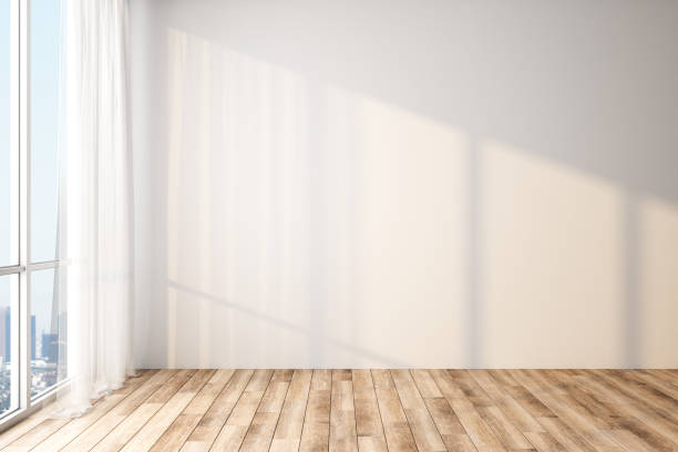istock Modern light empty room with blank white wall, wooden floor and big window with city view. 1192680136