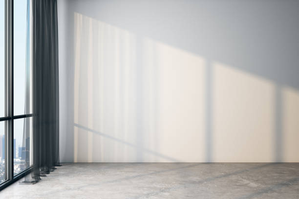 istock Modern light empty room with blank white wall, concrete floor and big window with city view. 1192680333