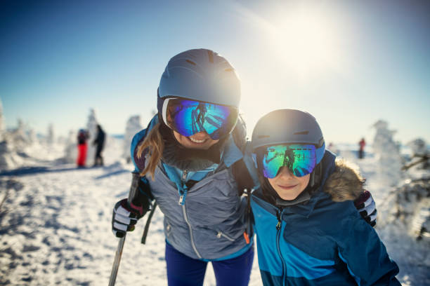 madre e hijo esquiando en el hermoso día soleado de invierno - skiing snow skiing helmet fun fotografías e imágenes de stock