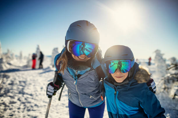 madre e figlio sciano in una bellissima giornata invernale soleggiata - skiing family winter snow foto e immagini stock
