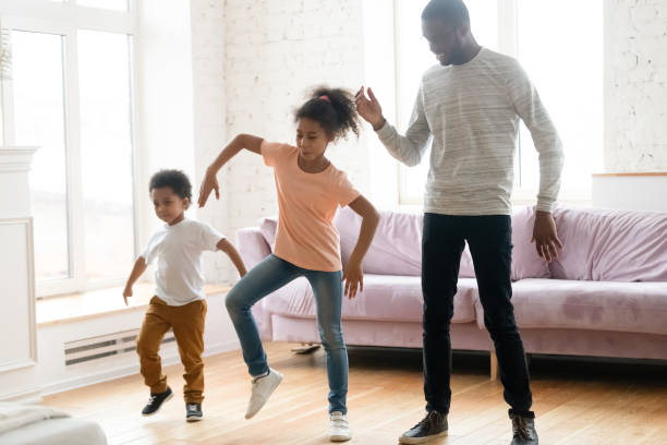 istock Happy african American dad have fun dancing with kids 1192687331