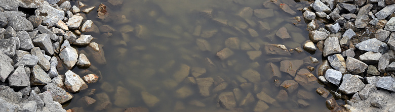 A river that flows through a rocky riverbed. An interesting structure of stones.