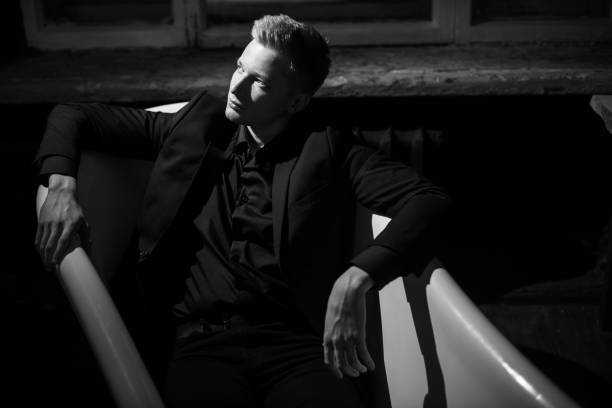 istock Man in black clothes is lying in empty bath 1192694709