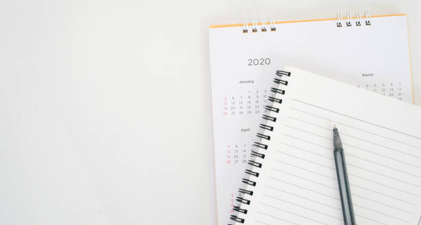 istock close up top view on  white calendar schedule background with pen and notebook to make appointment meeting or manage timetable each day for planning work in new year 2020 resolution concept 1192695217