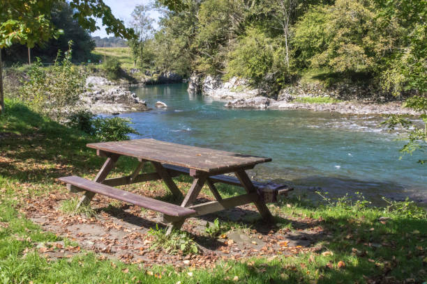 istock Wooden table and bench by the mountain river 1192696216