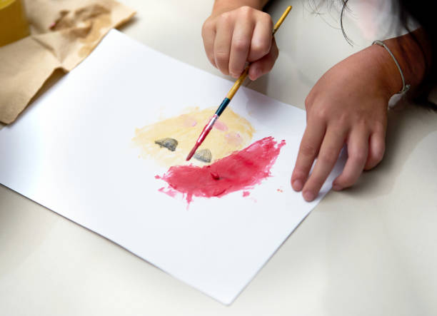 istock Kid hand make art activity with brush and coloring on paper on floor 1192697342