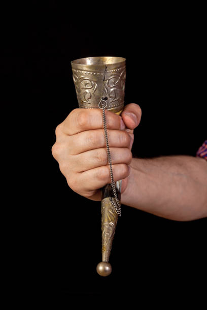 istock Hand holds horn for wine on black background 1192697465
