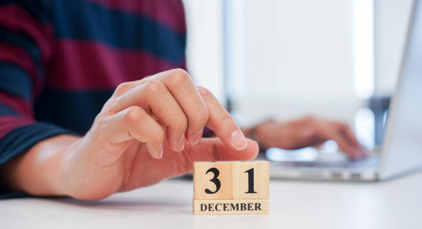 z bliska pracownik ręka umieścić numer 1 drewna w kształcie kostki, aby data kalendarza 31 grudnia w biurze na ostatni dzień ostatniej koncepcji odliczania roku - year block cube new years eve zdjęcia i obrazy z banku zdjęć
