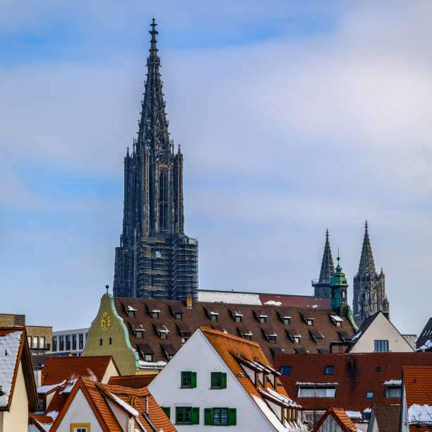 A woman sitting on a chair and looking at the Ulmer Munster (Ulm Cathedral) in fog; the tallest medieval church in the world. Ulm, Baden-Wurtemberg, Germany.
