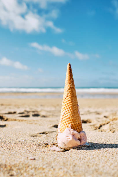istock Dropped strawberry flavoured Ice cream cone on the sand. 1192698978