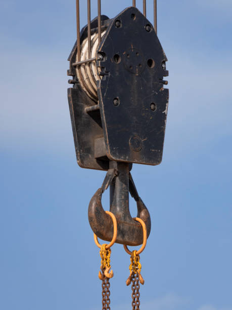 istock Crane hook with red and white stripes hanging, blue sky in background 1192701736
