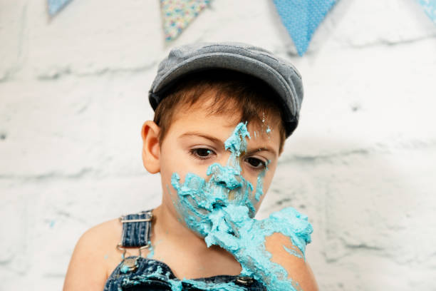 istock smashcake session, first cake of a 3-year-old boy with multiple disabilities. enjoying a lot while eating and getting dirty with blue cream 1192707089