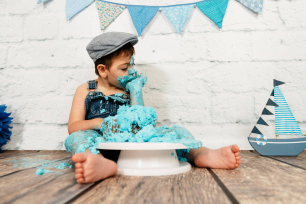 istock smashcake session, first cake of a 3-year-old boy with multiple disabilities. enjoying a lot while eating and getting dirty with blue cream 1192707179