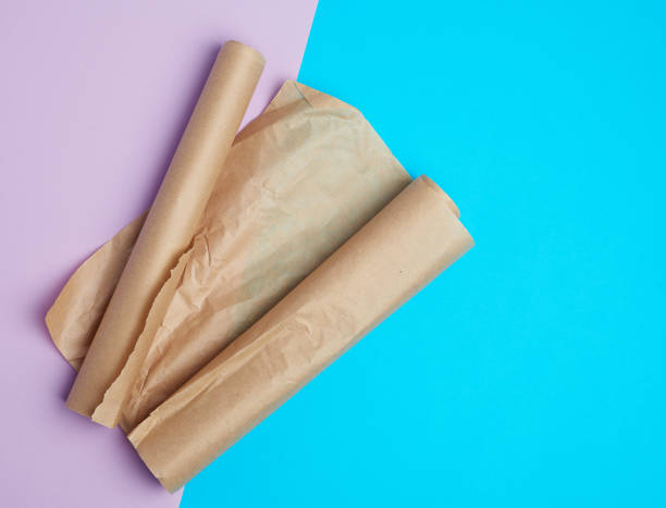 istock two rolled rolls of brown parchment baking paper on a colored background 1192707189