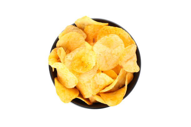 istock Potato chips in a black bowl isolated on white background, space for text. Top view 1192707472
