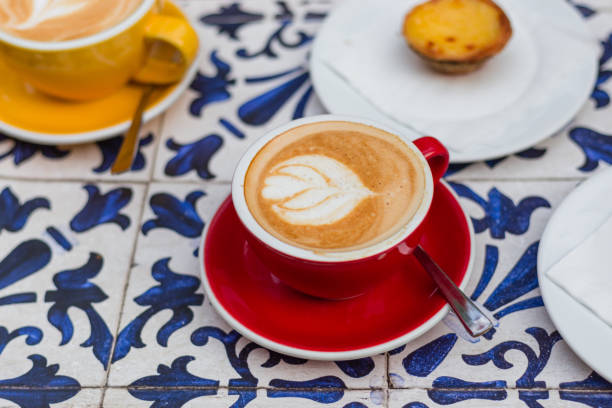 two cups of coffee latte in ceramic cups with traditional portuguese dessert pastel de nata. - pastel de nata ilustrações imagens e fotografias de stock