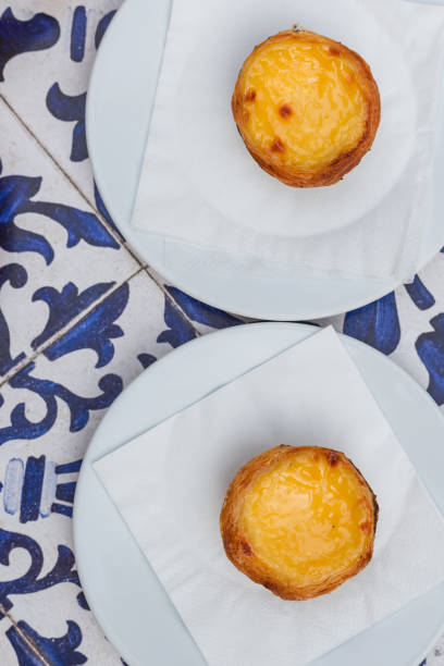 egg tart, traditional portuguese dessert pastel de nata on blue textile background. top view. - pastel de nata ilustrações imagens e fotografias de stock