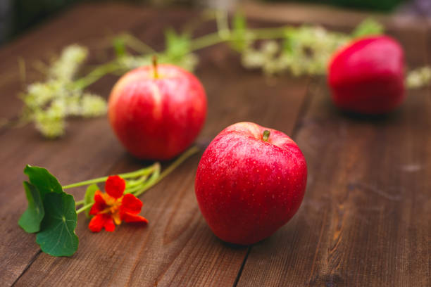 Ripe red apples on a wooden board